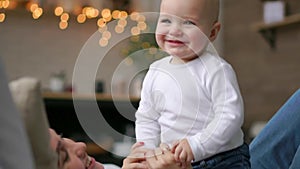 Young cute girl playing with her son on the bed. A young mother is playing with a baby on the bed.