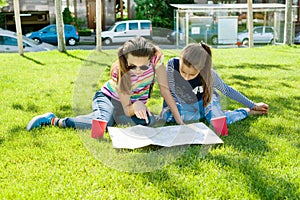 Young cute girls teens with map of european city outdoors