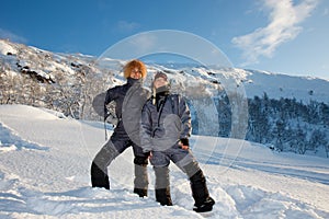 Young cute happy laughing female women models in snowy trees branches smiling from fun and joy in falling down white snow in