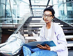 Young cute indian girl at university building sitting on stairs