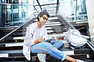 Young cute indian girl at university building sitting on stairs