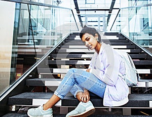 Young cute indian girl at university building sitting on stairs