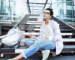 Young cute indian girl at university building sitting on stairs