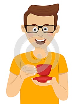 Young cute man with glasses holding cup of tea or coffee