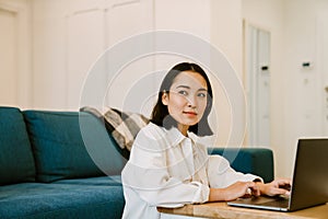 Young cute serious asian woman with laptop working