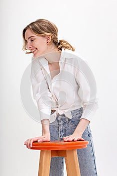 Young cute smiling caucasian girl in white shirt, blue jeans laughing at studio