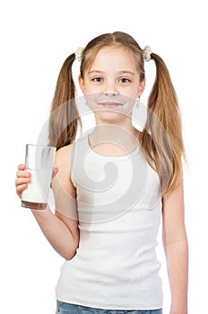 Young cute smiling girl with two hair tails and milky moustache holds a glass of milk