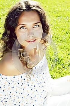 young cute summer girl on green grass outside relaxing smiling, lifestyle people concept