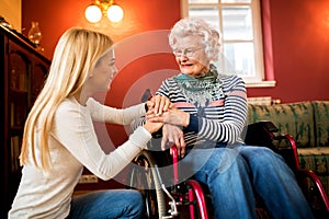 Young cute woman comfort her grandmother in wheelchair