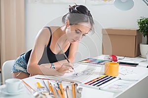 Young cute woman painting aquarelle picture portrait of a artist at the workplace