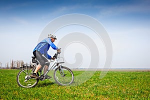 Young cyclist cycling in the spring park