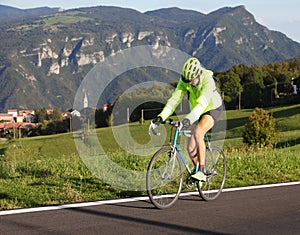 Young cyclist with racing bicycle and phosphorescent waterproof