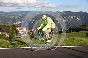 Young cyclist with racing bicycle and phosphorescent waterproof