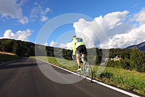 Young cyclist with racing bicycle and phosphorescent waterproof