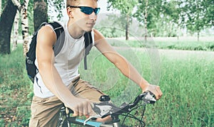 Young cyclist riding on bicycle in summer park
