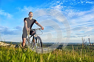 Young cyclist riding the bike on the beautiful summer mountain trail.