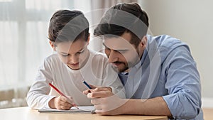 Young dad drawing together with preschooler son