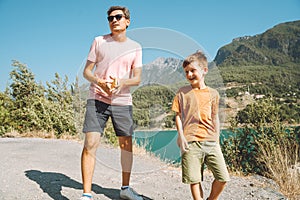 Young dad and his son standing on Mountain View. Child kid boy having fun with father and hiking hiking near mountains