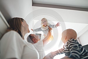 Young dad play with daughter throws up and hold her in hands