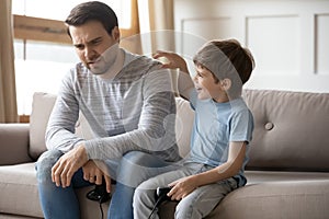 Young dad and small son play computer video game