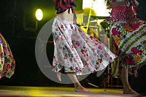 Young dancer woman barefoot in gypsy dress dancing on stage