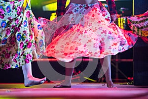 Young dancer woman barefoot in gypsy dress dancing on stage