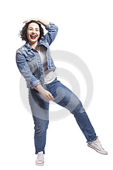 Young dancing plump girl. Beautiful curly brunette with red lips in jeans. Body positivity and freedom. Isolated on white