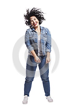 Young dancing plump girl. Beautiful curly brunette with red lips in jeans. Body positivity and freedom. Isolated on white