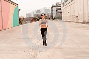 Beautiful Young dark haired athlete woman doing sprint sprinting outdoors. Concept of full life, natural and healthy life. Women`