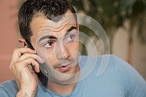 Young dark haired male model talking on his cell phone