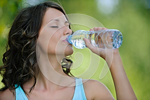 Young dark-haired woman drinking water