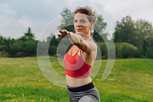 Young dark-haired woman fond of sport stretching her muscles