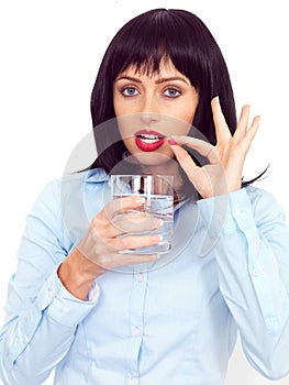 Young Dark Haired Woman holding a Glass of Water Taking Medicine