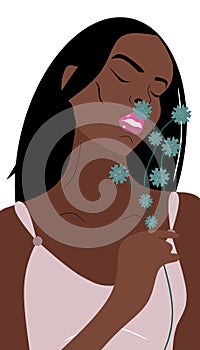 Young dark skinned woman holds blue green field flower in elegant pose and smells it.