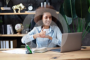 Young deaf african-american businesswoman have digital virtual online conference with employees on computer, talking on video call