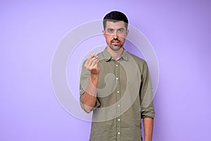Young deaf mute man asking money using sign language on blue background