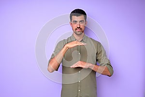 Young deaf mute man saying celling using sign language on blue background