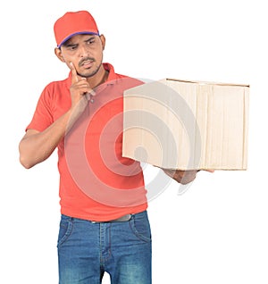 Young delivery man holding carton box and thinking in uniform