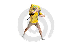 Young delivery man in yellow uniform running to deliver order isolated on white background. Concept of convenience