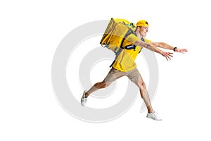 Young delivery man in yellow uniform running to deliver order isolated on white background. Concept of convenience