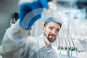 Young dentist consulting an x ray film on the background at the dental office