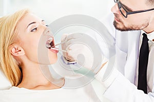 Young dentist examining patient in dental clinic.