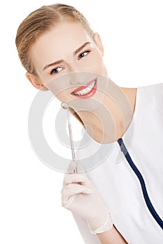 Young dentist with small mirror to checking up teeth.