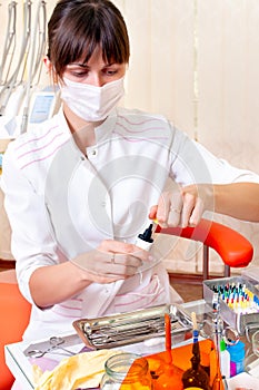 Young dentist is working in her office