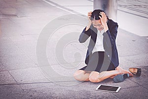 Young depressed businesswoman sitting on the floor