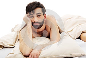 Young depressed man in bed.