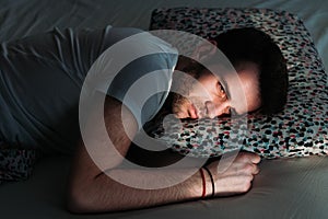 Young depressed man in pain on the bed