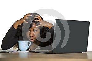Young depressed and overwhelmed black African American business woman working frustrated at office computer desk feeling upset and