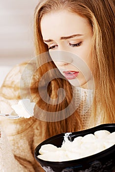 Young depressed woman is eating big bowl of ice creams to comfort herself.