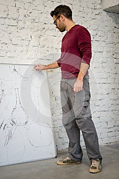 Young Designer Drawing the Sketch on the Big Whiteboard in White Studio